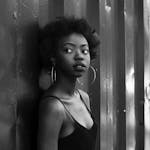 Elegant black and white portrait of a woman in a studio, showcasing modern fashion.